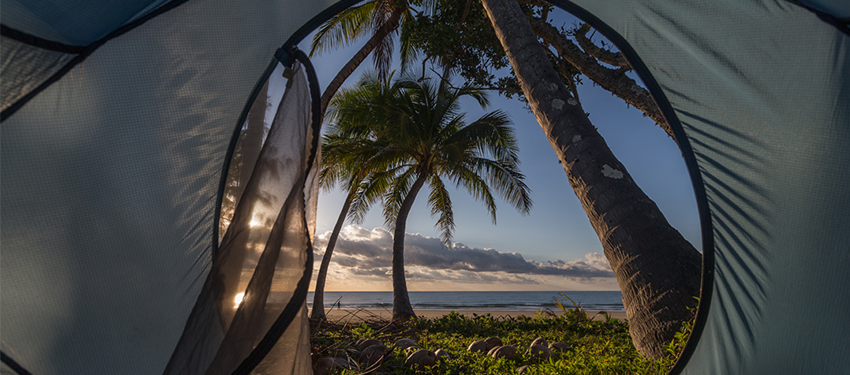 View of the beach and sunrise from inside tent.